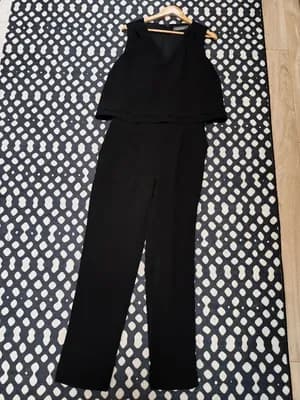 Combinaison pantalon femme noire posée au sol