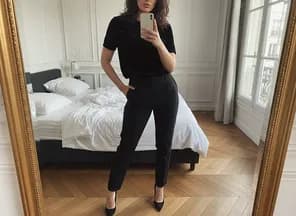 T-shirt noir porté par mannequin femme IA dans un salon parisien